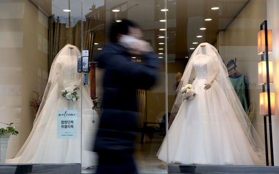 A passenger passes by a wedding shop in Mapo District, western Seoul, on Tuesday. [YONHAP]