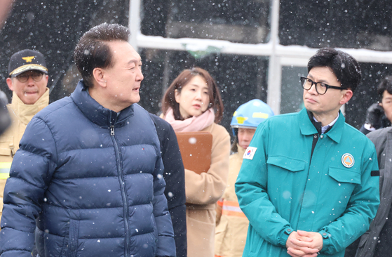 President Yoon Suk Yeol, left, and People Power Party interim leader Han Dong-hoon visit the site of a fire at a traditional market for marine products in Seocheon County, South Chungcheong, on Jan. 23. [JOINT PRESS CORPS]