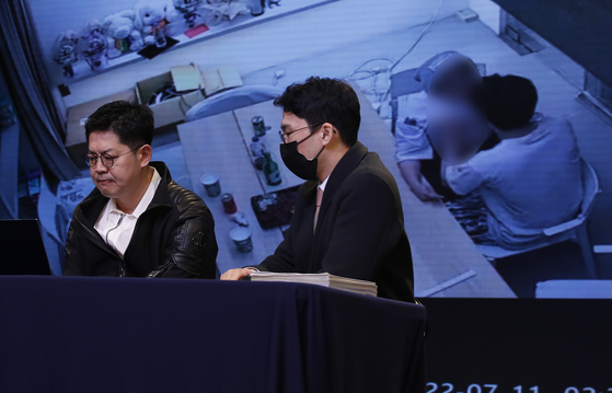 Spire Entertainment CEO Hwang Sung-woo, left, reveals surveillance camera footage of Omega X member Lee Hwi-chan groping the agency's former CEO and Hwang's wife Kang Seong-hee in July 2022, during a press conference held on Tuesday in southern Seoul. [NEWS1]