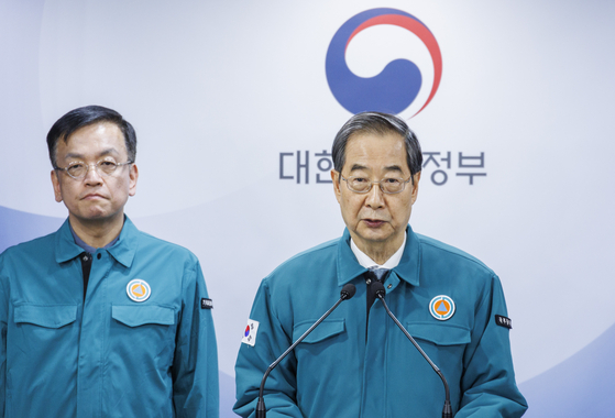 Prime Minister Han Duck-soo, right, speaks during a public address on governmental medical reform at the government complex in central Seoul on Wednesday. [YONHAP] 
