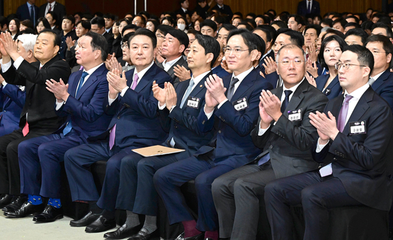 President Yoon Suk Yeol, third from left, and the heads of the country's major conglomerates, including Samsung Electronics Chairman Lee Jae-yong (fifth from left), SK Group Chairman Chey Tae-won (second from left), Hyundai Motor Executive Chair Euisun Chung (sixth from left) and LG Chairman Koo Kwang-mo (seventh from left), attend a ceremony to mark the 51st Commerce and Industry Day at a convention center in Seoul on March 20. [JOINT PRESS CORPS]