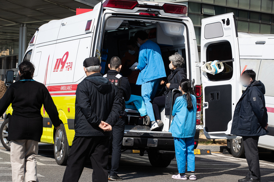 Medical professionals check the condition of a patient transported by an ambulance at a general hospital in downtown Seoul on Thursday. [NEWS1] 