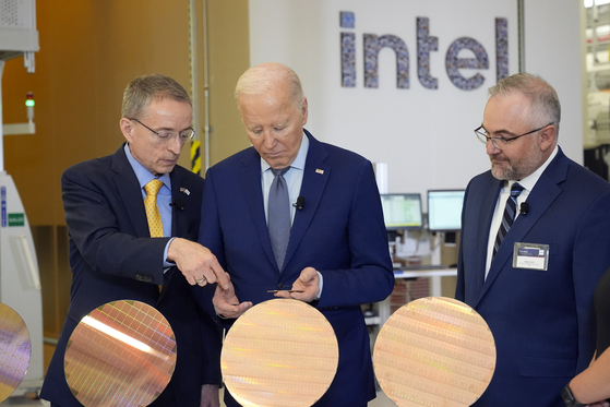 President Joe Biden listens to Intel CEO Pat Gelsinger, left, as Intel factory manager Hugh Green watches during a tour of the Intel Ocotillo Campus, in Chandler, Ariz., on Wednesday. [AP]