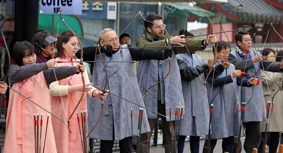 At the Yeonmudae Post inside the palace, visitors can try their hand at archery in the open fields. The post used to be a training ground for military troops. The culture minister, fourth from left, gives a go at archery at the military post during his visit to Suwon last month. [MINISTRY OF CULTURE, SPORTS AND TOURISM]