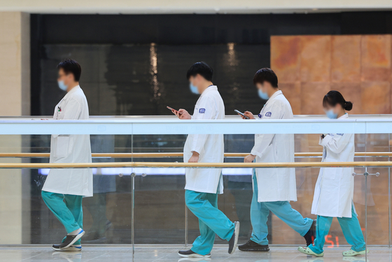 Medical professionals walk inside a general hospital in Seoul on Wednesday. [YONHAP] 