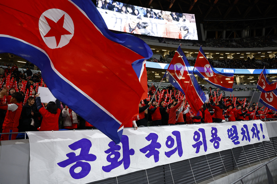 Football fans supporting North Korea in the stands before a 2026 World Cup qualifier begins at Japan National Stadium in Tokyo, Japan on Thursday. [REUTERS]