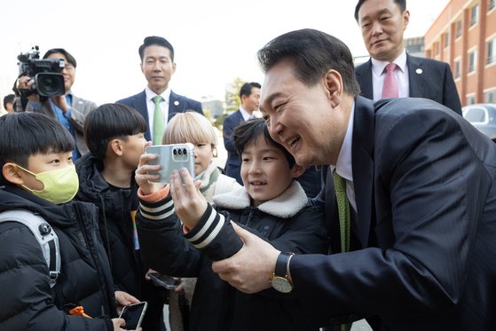 President Yoon Suk Yeol, right, takes a selfie with students at an elementary school in Wonju, Gangwon, on Thursday. [PRESIDENTIAL OFFICE] 