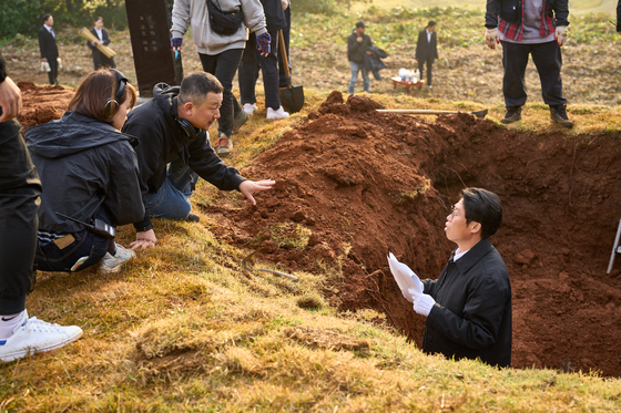 A behind-the-scenes image from ″Exhuma,″ with director Jang Jae-hyun, left, and actor Yoo Hae-jin [SHOWBOX]