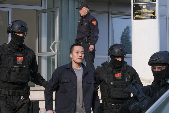 Montenegrin police officers escort South Korean citizen and Terraform Labs founder Do Kwon in Montenegro's capital Podgorica, Saturday, March 23, 2024. Kwon was transferred on Saturday from prison, where he had served a four-month sentence for using a fake passport, to a facility for foreigners pending his announced extradition to his native Korea. [AP/YONHAP]