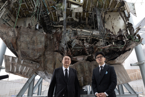 President Yoon Suk Yeol, left, and People Power Party (PPP) interim leader Han Dong-hoon view a salvaged ship in a sign of political unity after attending a ceremony marking West Sea Defense Day at the Navy's 2nd Fleet Command in Pyeongtaek, Gyeonggi, on Friday. [PRESIDENTIAL OFFICE]
