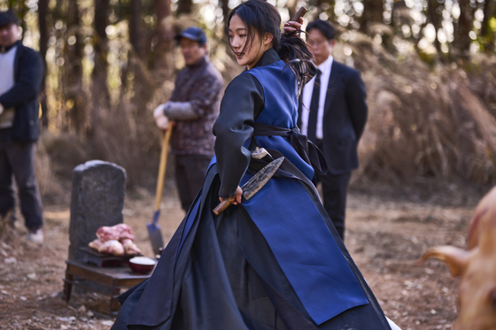 Actor Kim Go-eun as shaman Hwa-rim performing a shamanistic ritual known as gut as a grave gets exhumed in director Jang Jae-hyun's latest film "Exhuma." [SHOWBOX] 