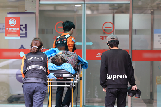 A patient is transferred by paramedics to an emergency room at a secondary care hospital in downtown Seoul on Monday morning. [YONHAP] 