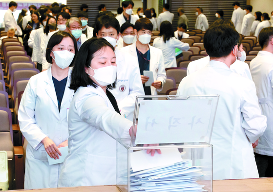 Medical professors of Korea University submit their resignations at a general assembly at its Anam Hospital in central Seoul on Monday morning. [YONHAP] 