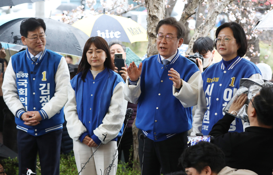 Democratic Party leader Lee Jae-myung, second from right, speaks at a campaign event in Gimhae, South Gyeongsang, on Monday. [NEWS1]