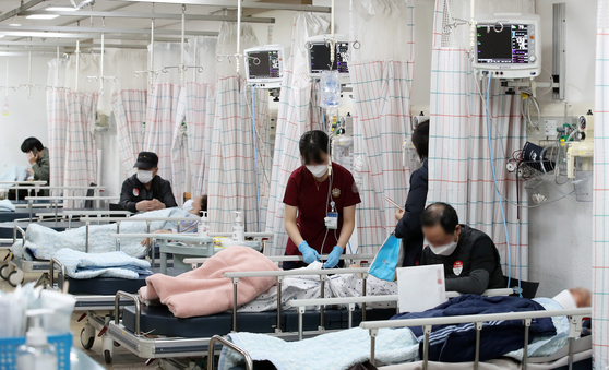 Medical professionals take care of patients at an emergency room at a general hospital in Daegu on Tuesday. [NEWS1]