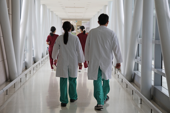 Medical professionals walk inside a corridor at a general hospital in downtown Seoul on Monday. [YONHAP]