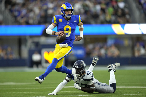 Los Angeles Rams quarterback Matthew Stafford, left, runs the ball after evading a tackle from Seattle Seahawks linebacker Darrell Taylor during the second half of an NFL football game on Nov. 19, 2023 in Inglewood, Calif. [AP/YONHAP]