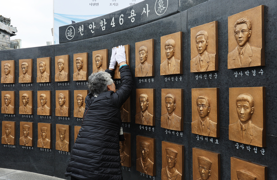A bereaved woman sheds tears at a memorial for the 46 sailors killed in the sinking of the ROKS Cheonan corvette in 2010 at the Second Fleet in Pyeongtaek, Gyeonggi, Tuesday. A Navy ceremony was held on this day, attended by family members of victims, survivors and military officials to mark the 14th anniversary of North Korea's torpedo attack on the South Korean warship near the western Northern Limit Line, the de facto inter-Korean sea border, in the Yellow Sea in March 2010. [YONHAP]
