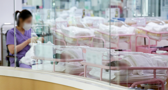 A woman takes care of a baby at a postnatal care center in Seoul. [YONHAP]