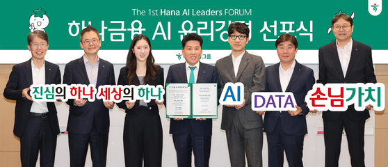 Hana Financial Group Chairman Ham Young-joo, center, holds a copy of the company’s ethics code during the Hana AI Leaders Forum held at the company headquarters in central Seoul on Tuesday. [HANA FINANCIAL GROUP]