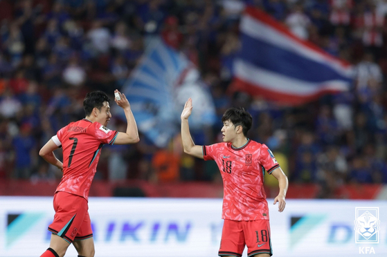 Korea's Son Heung-min, left, and Lee Kang-in celebrate during a World Cup qualifier against Thailand at Rajamangala Stadium in Bangkok on Tuesday.  [NEWS1]