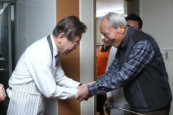 Democratic Party leader Lee Jae-myung shakes hands with an older adult at a senior center in Yeongdeungpo District, western Seoul, on Dec. 21, 2023. [YONHAP]