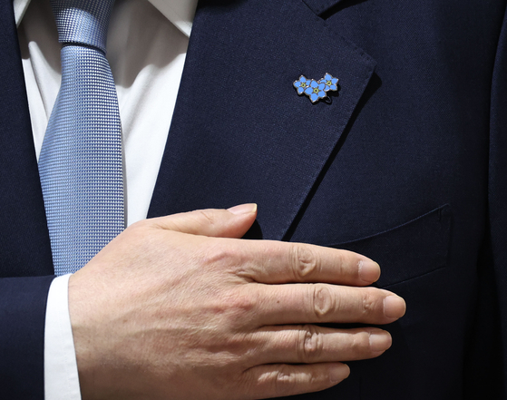 President Yoon Suk Yeol wears a forget-me-not pin, a symbol of hope for the repatriation of South Koreans abducted and detained in North Korea, as well as prisoners of war, on his lapel during a Cabinet meeting at the Yongsan presidential office in Seoul on Tuesday. [JOINT PRESS CORPS]