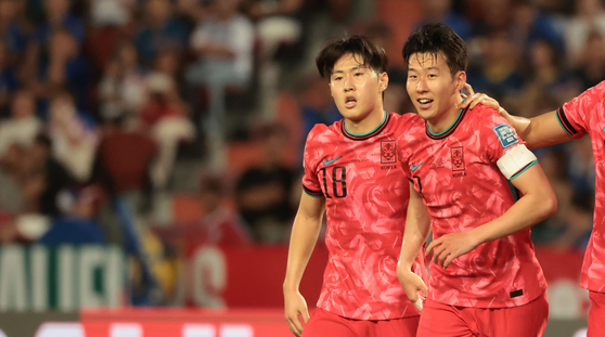 Korea's Lee Kang-in, left, and Son Heung-min celebrate during a World Cup qualifier against Thailand at Rajamangala Stadium in Bangkok on Tuesday.  [YONHAP]