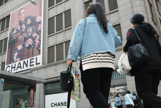 People pass by the Chanel window display in a department store in Seoul on Wednesday. [NEWS1]