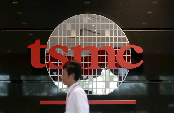 An employee walks in front of the logo of TSMC at its headquarters in Hsinchu, northern Taiwan, November 19, 2015. [REUTERS/YONHAP]
