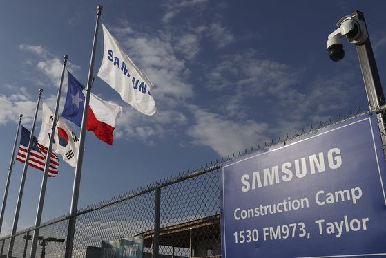 A Samsung, Texas, South Korea, and United States flag hang in front of the Samsung semiconductor chip plant in Taylor, Texas, USA, 02 January 2024. Samsung's semiconductor chip plant, which was supposed to be finished in 2024, will not be finished until 2025. The new plant will employ 2,000 people, and the cost of the project is $17 billion. [EPA/YONHAP]
