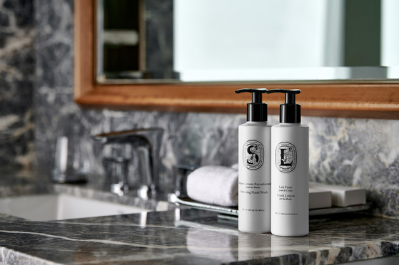 Signiel Hotel provides Diptyque bathroom amenities in multi-use dispensers. [LOTTE HOTELS & RESORTS]