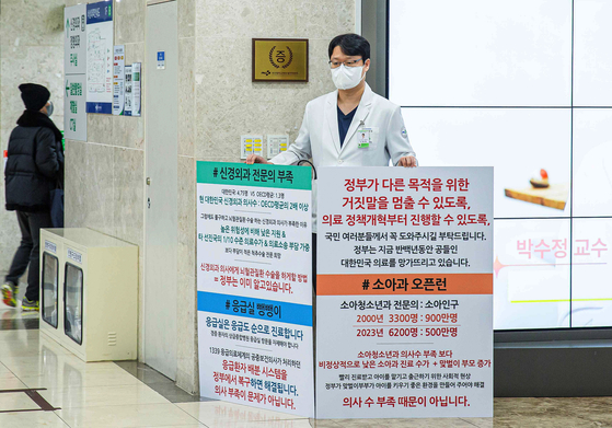 A professor of rehabilitation medicine stages a one-man rally in protest of the government’s decision to add 2,000 seats in medical schools’ admission quota on Thursday at Pusan National University Hospital in Busan. The protest sign says that the health care problem is not about shortage of doctors. [PUSAN NATIONAL UNIVERSITY HOSPITAL]