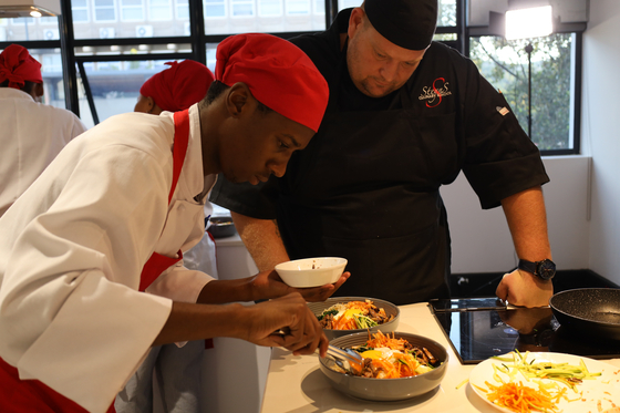 Students learn how to make bibimbap at a Korean food workshop held at the Korean Cultural Center in South Africa on March 8. [KOREAN CULTURAL CENTER SOUTH AFRICA]