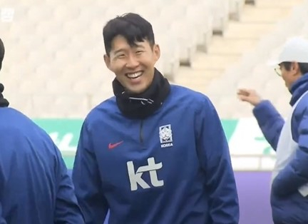 Korean national team captain Son Heung-min smiles after talking with his teammate during a training session on March 20. [SCREEN CAPTURE]