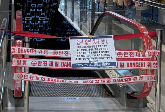 An escalator in Good Morning City is blocked with a notice saying "temporarily closed due to business downturn affected by the pandemic." [KIM JI-YE]