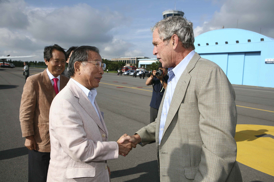 Hyosung Group Honorary Chairman Cho Suck-rai shake hands with former U.S. President George W. Bush at Jeju Summer Forum in July 2009. [HYOSUNG GROUP]