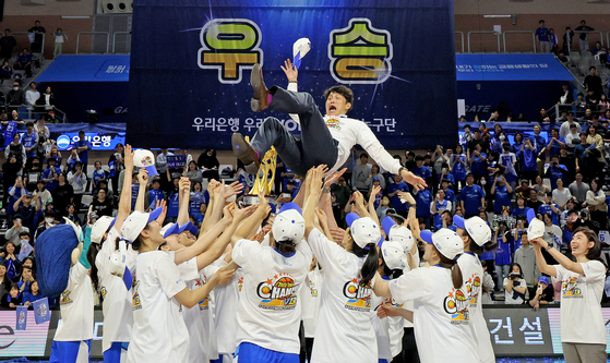 Asan Woori Bank Woori Won players toss head coach Wie Sung-woo into the air after winning the 2023-24 WKBL Championship at Asan Yi Sun-sin Gymnasium in Asan, South Chungcheong on Saturday. [NEWS1]