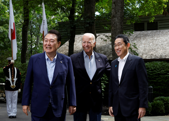 From left, Korean President Yoon Suk Yeol, U.S. President Joe Biden and Japanese Prime Minister Fumio Kishida pose for a photo during a trilateral summit at Camp David near Thurmont, Maryland on Aug. 18, 2023. [REUTERS/YONHAP]