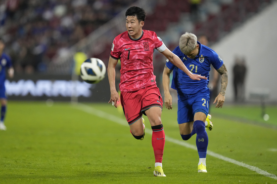 Korea's Son Heung-min, left, and Thailand's Suphanan Bureerat battle for the ball during a 2026 World Cup qualifier at Rajamangala national stadium in Bangkok, Thailand on March 26. [AP/YONHAP]