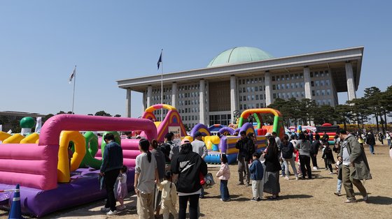 Children visitors have fun on hot-air balloon bounce houses installed in front of the National Assembly building in Yeouido, western Seoul on Sunday. The National Assembly opened its compound to the public on Sunday to let citizens enjoy the cityscape and make fond springtime memories with the Yeouido Spring Flower Festival. [NEWS1]