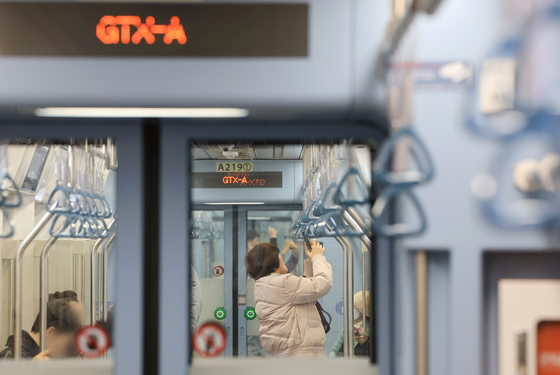 A woman taking a photo of the interior of the GTX-A train after boarding from Suseo Station on Sunday. [YONHAP]