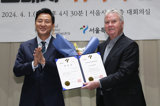 Seoul Mayor Oh Se-hoon, left, and Guus Hiddink, the former national football team's head coach, pose for a photograph after the Dutchman was appointed as the Seoul Philharmonic Orchestra's honorary ambassador on Monday at the City Hall in central Seoul. [NEWS1] 