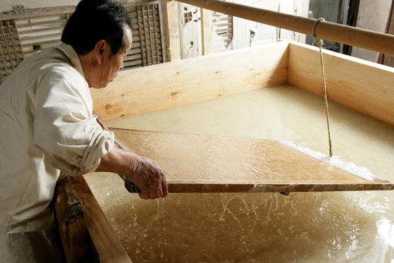 The late hanji craftsman Ryu Hang-young works on making traditional Korean paper. [CULTURAL HERITAGE ADMINISTRATION] 
