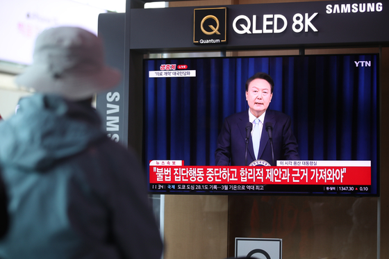 A person watches a televised presidential speech at Seoul Station on Monday. President Yoon Suk Yeol made an address to the nation on his government's medical reform plans amid a clash with doctors' groups at the presidential office in Yongsan, central Seoul. [NEWS1]