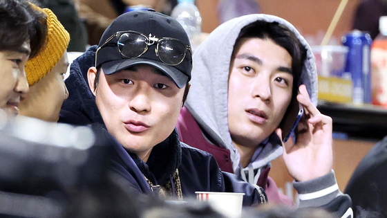 Lee Jung-hoo, right, and Kim Ha-seong watch Game 5 of the Korean Series at Jamsil Baseball Stadium in southern Seoul on Nov. 13, 2023.  [YONHAP]