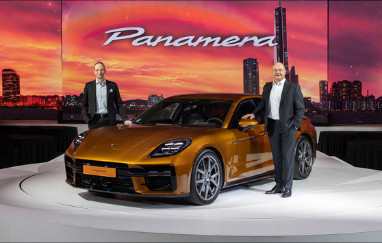 Porsche Korea CEO Holger Gerrmann, left, and Thomas Friemuth, head of the Panamera product line at Porsche AG, pose with the new Panamera Turbo E-Hybrid at a launching event in central Seoul on Tuesday. [PORSCHE KOREA]