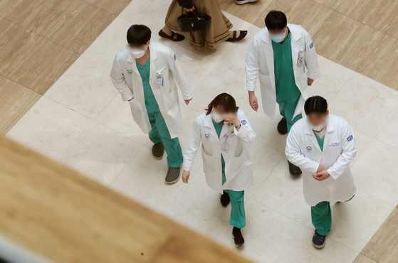 Four medical professionals walk inside a general hospital in Seoul. [NEWS1]