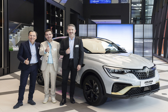 From left, Arnaud Belloni, vice president of Renault Group heading global marketing, Renault Korea CEO Stephane Deblaise, and Gilles Vidal, design director at Renault, take a photo with Arkana, previously known as XM3 in Korea, after a press conference Wednesday in eastern Seoul. [RENAULT KOREA] 