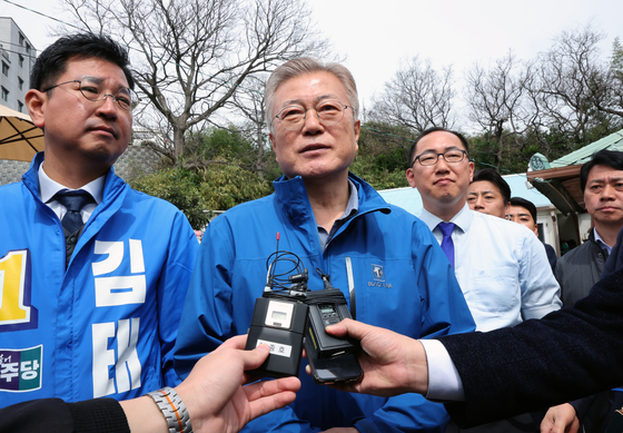 Former president Moon Jae-in, center, speaks to the press during an election campaign in Ulsan on Tuesday. [YONHAP]